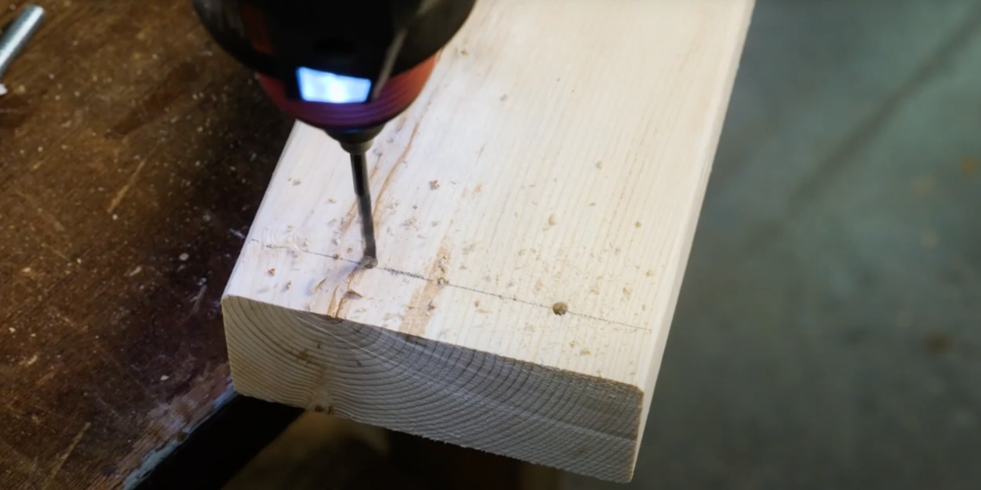 Сборка рамки выполняется следующим образом: на каждой длинной доске проведите карандашом ровную линию на расстоянии 2 сантиметров от узкого торца. Далее просверлите вдоль этой линии по паре отверстий сборка рамки