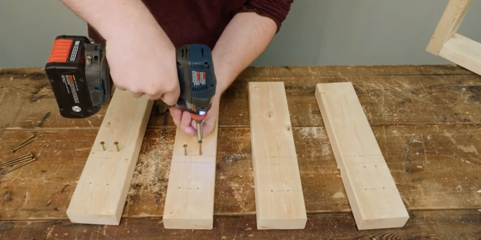 На оставшихся досках отметьте две линии: одну на расстоянии 8 см, а вторую — 16 см от одного из торцов. На каждой из этих линий просверлите по два отверстия. Саморезы в отверстия, расположенные ближе к центру досок, вкрутите не до конца сверлим по 2 отверстия